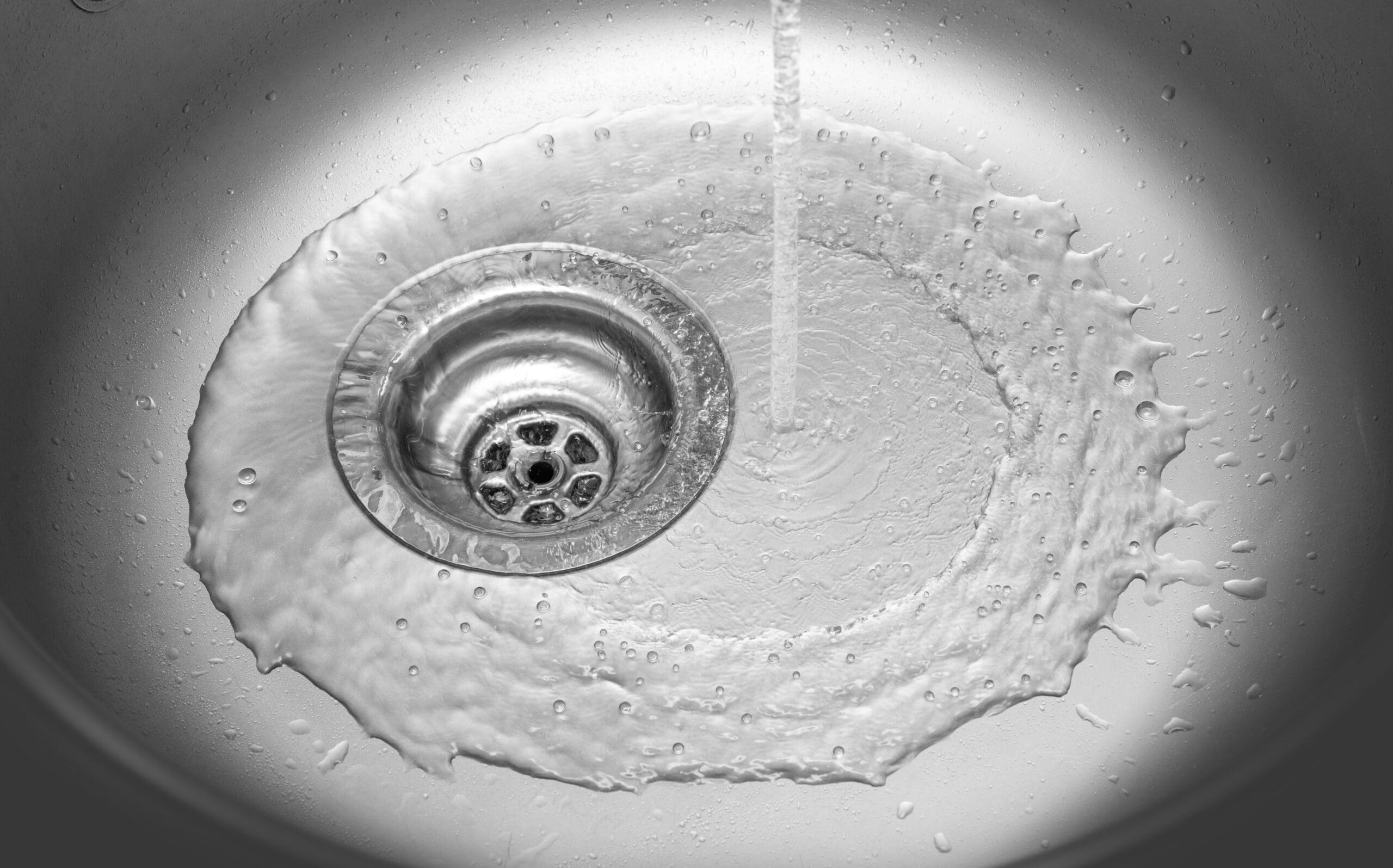 View of the sink, drain and flowing water.